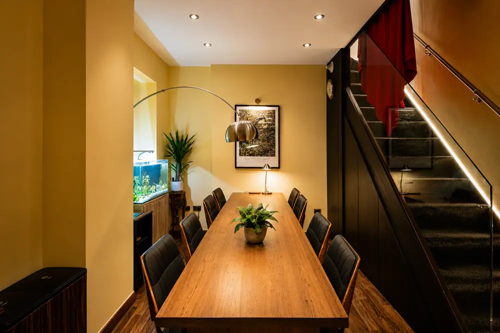 BC Atelier studio interior on Kensington Church Street — the long table, glass staircase and aquarium niche