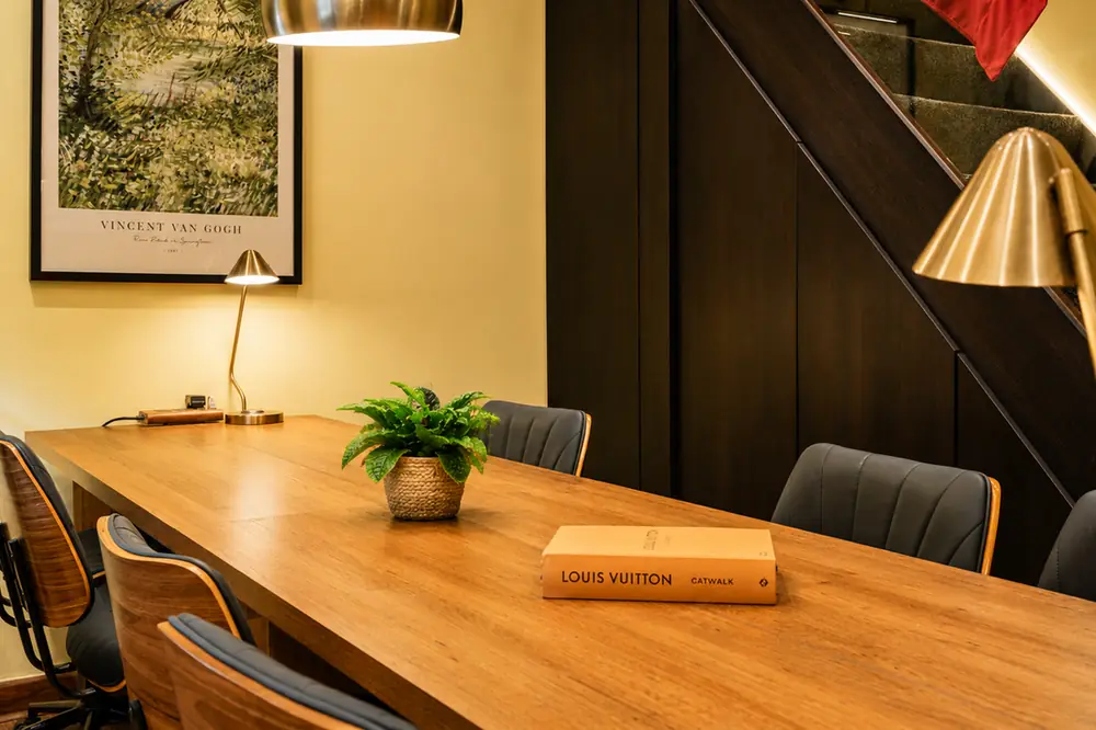Detail of a workspace table at BC Atelier — book, plant and morning light